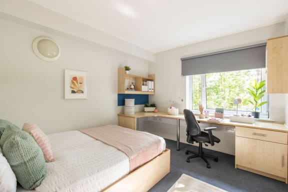 a bedroom with a bed and a desk with a chair