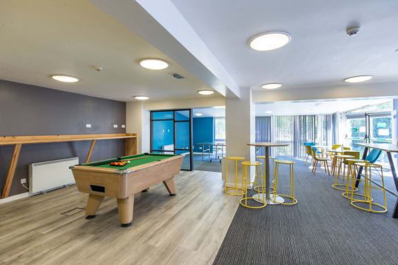 a games room with a pool table and bar