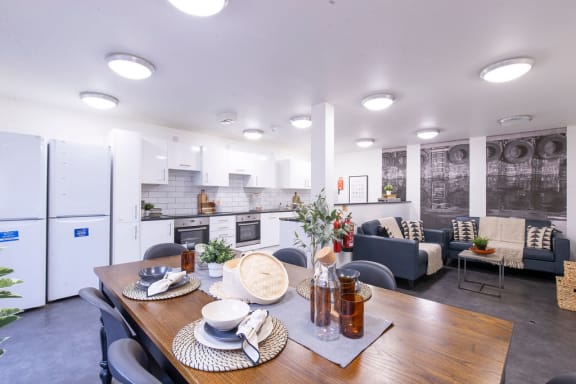 a kitchen and living room with a wooden table