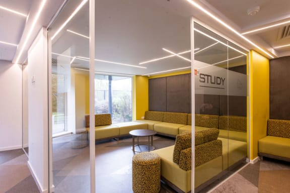 a lobby with yellow couches and a table