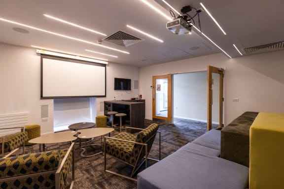 a room with a couch and tables and a projector