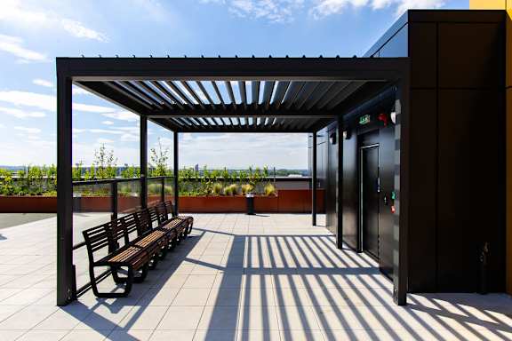 a row of benches sitting under awning on a roof
