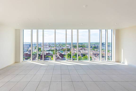 a view of a city from a room with tall windows