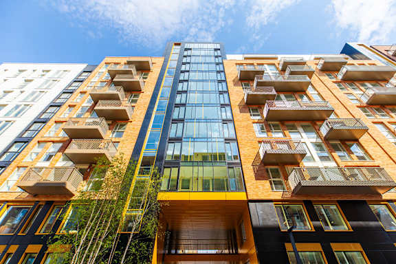 a tall building with many balconies and a blue sky