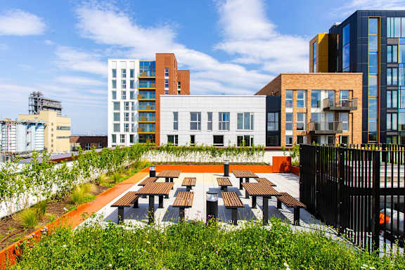 a communal terrace with tables and benches in a city
