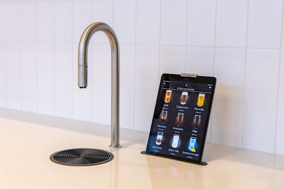 a tablet on a kitchen counter next to a faucet