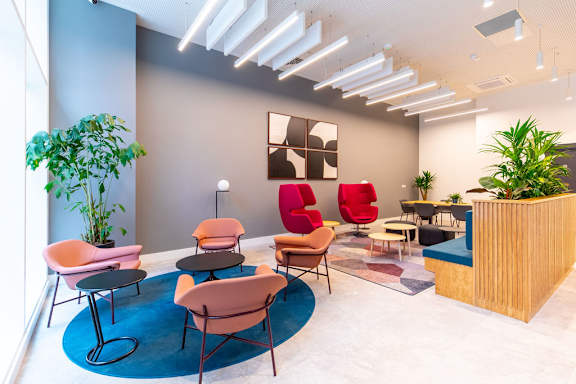 a lobby with chairs and tables and a reception desk