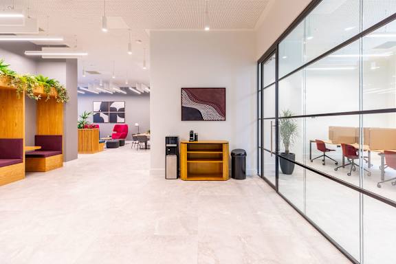 a lobby with glass doors and a table with a cabinet