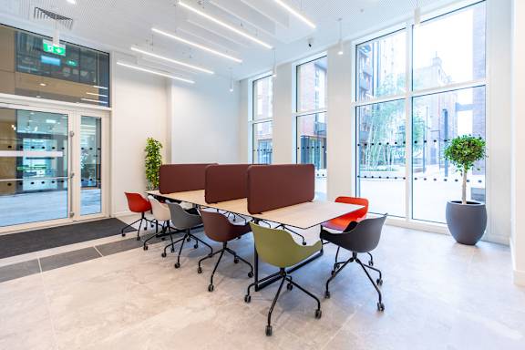 a large table with chairs in a room with windows
