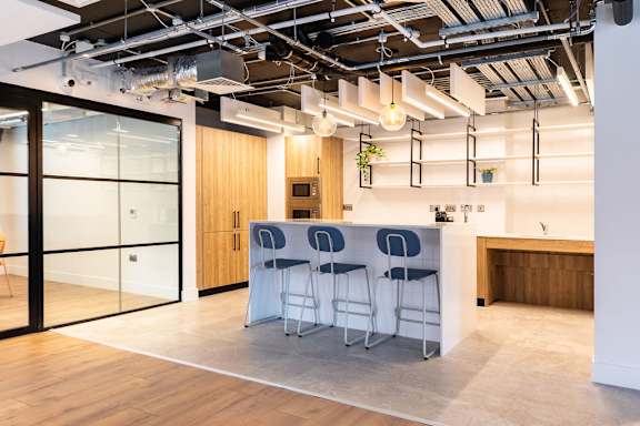 a kitchen with a table and chairs in a room with glass doors