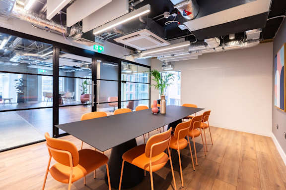 a conference room with a long table and orange chairs