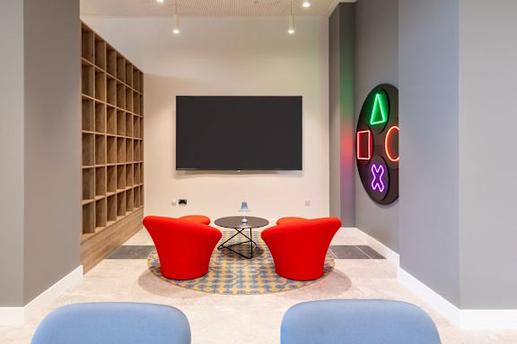 a room with chairs and a table and a television