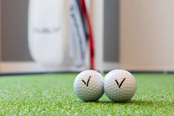 two golf balls sitting next to each other on the grass