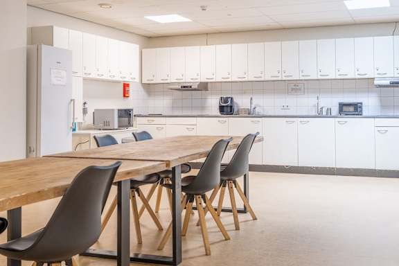 A kitchen with a table and chairs in the foreground.