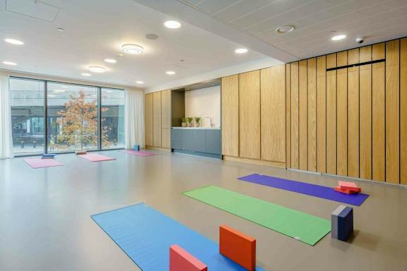 A yoga studio with wooden walls and a large window at Alameda Apartments, Wembley, HA9 0HS
