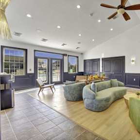 A living room with a green couch and a ceiling fan.