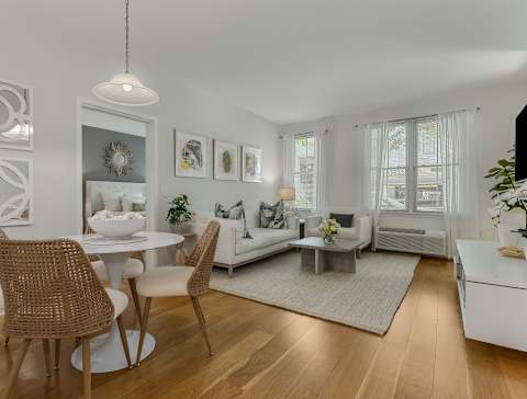 A modern dining room with a white table and chairs.