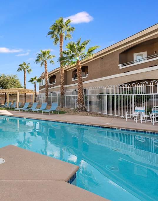 A large swimming pool with a brown diving board.