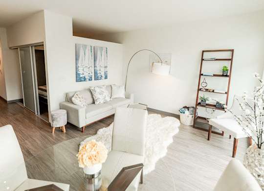 Apartments in Seattle, WA - Icon Apartments Modern Living Room Next to Kitchen with Hardwood Flooring and Natural Light at Icon Apartments, Washington, 98104