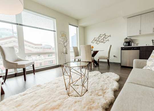 Apartments in Seattle, WA - Icon Apartments Modern Living Room Next to Kitchen with Hardwood Flooring and Natural Light at Icon Apartments, Seattle, WA