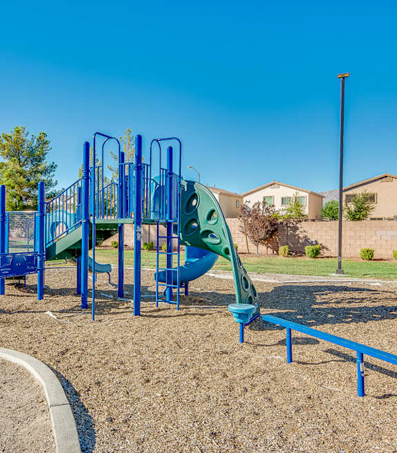 A playground with a blue slide and a green slide.