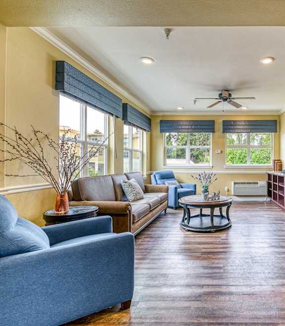 A living room with a blue couch and a brown sofa.