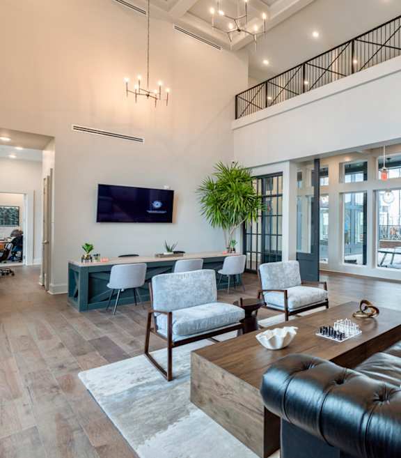 a living room with a brown leather couch and a wooden coffee table in front of a tv