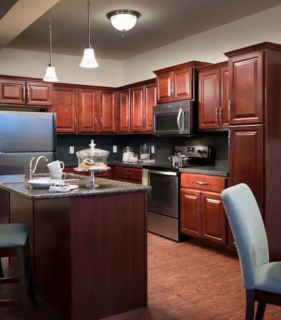 A kitchen with granite countertops and dark wood cabinets at Meridian West Shore, Pennsylvania 17055