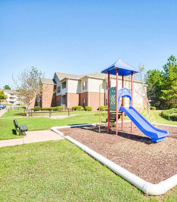 A playground with a blue slide and a red and blue structure.