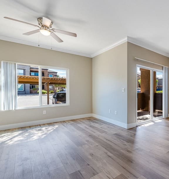 an empty living room with a ceiling fan