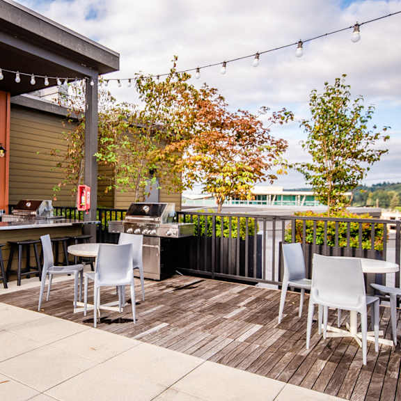 A patio with a table and chairs and a TV on the wall.