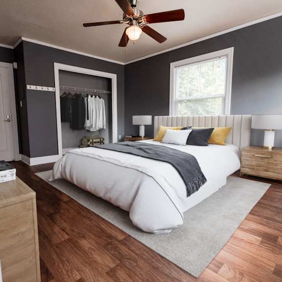 A bedroom with a bed, nightstands, and a ceiling fan.