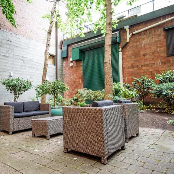 the courtyard has a seating area with furniture and plants