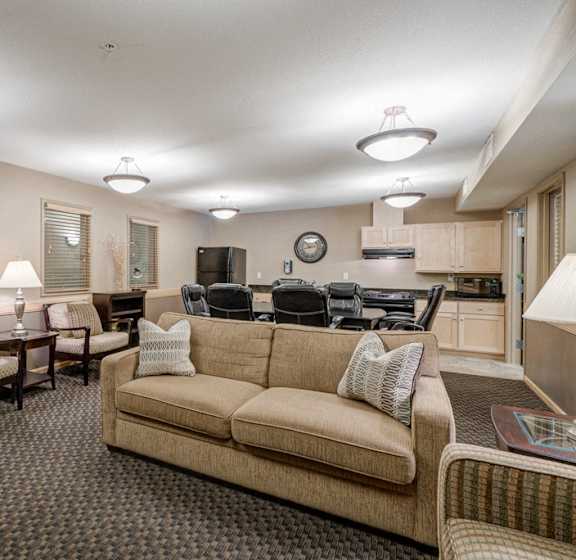 A living room with a couch, chairs, and a television.