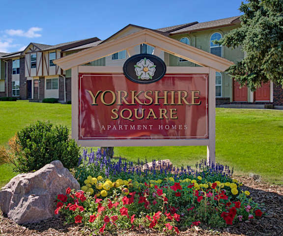 Yorkshire Apartments Sign The exterior sign with trees and surrounded by greenery with the buildings in the background of Yorkshire Square Apartment Homes.