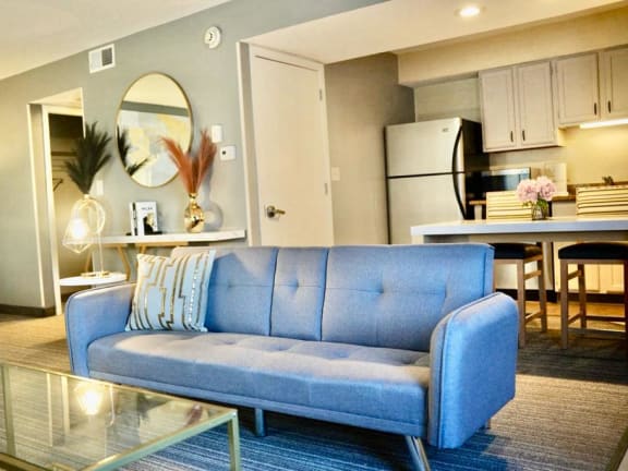 a living room with a blue couch and a table