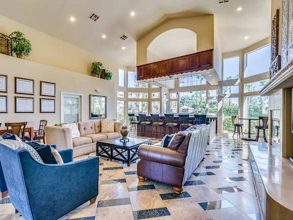 A living room with a blue couch and a brown leather chair.