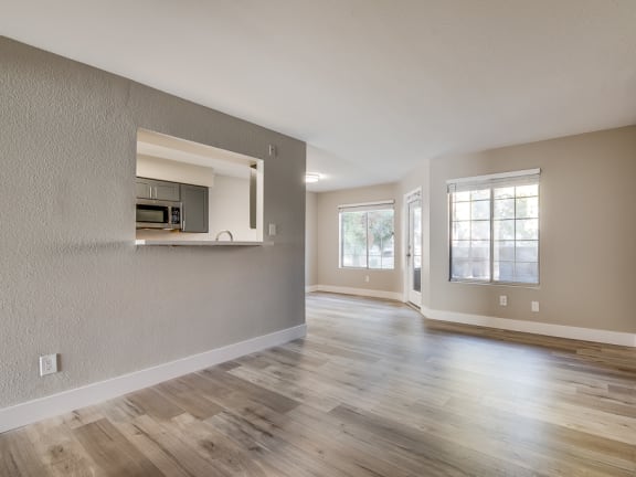 an empty living room with a microwave and a window