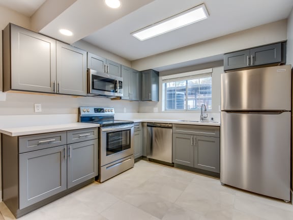 a kitchen with stainless steel appliances and gray cabinets