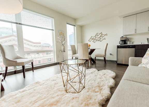 Apartments in Seattle, WA - Icon Apartments Modern Living Room Next to Kitchen with Hardwood Flooring and Natural Light at Icon Apartments, Seattle, WA