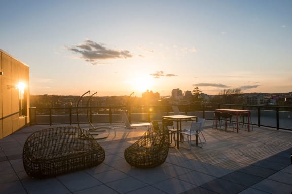 the rooftop terrace at sunset with chairs and a table