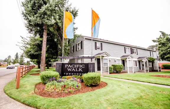 the front of a house with a lawn and trees at Pacific Walk, Lakewood