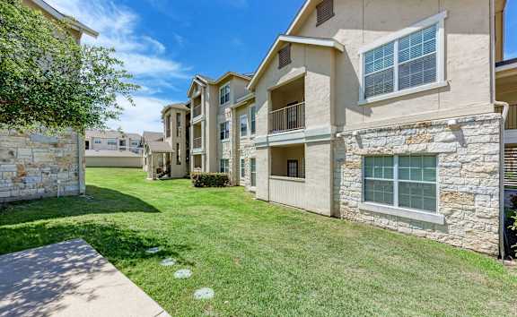 A row of houses with a green lawn in between.