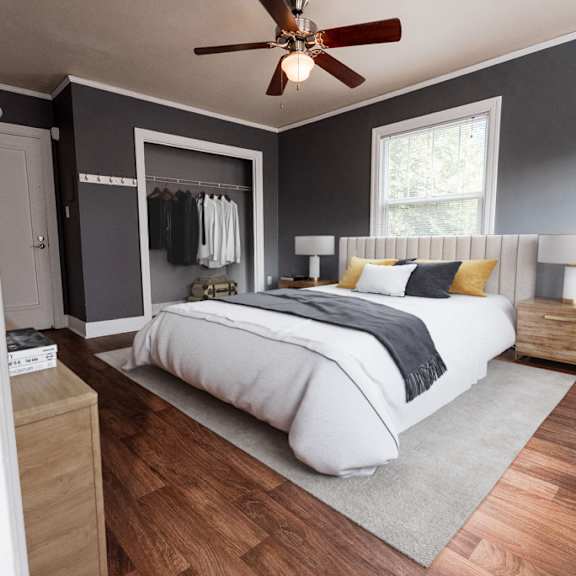 A bedroom with a bed, nightstands, and a ceiling fan.