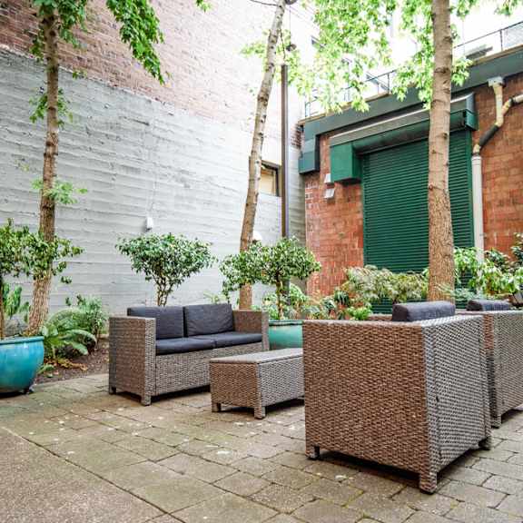 the courtyard has a seating area with furniture and plants