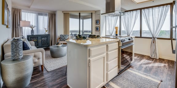 a kitchen with an island and a living room in the background