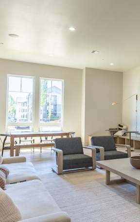 A modern living room with a fireplace and a large window overlooking a pool at Northplace Apartment Homes, Salem, Oregon