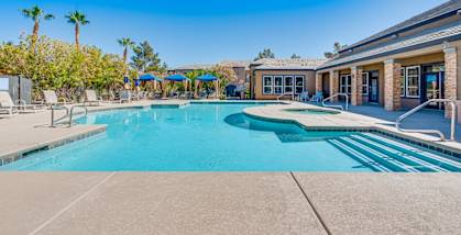 our resort style swimming pool is in front of our club house with umbrellas