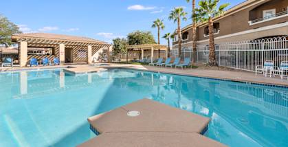 A large swimming pool with a brown diving board.