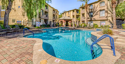 a swimming pool with an apartment building in the background